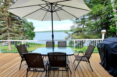 Patio extérieur avec BBQ table et parasol   © Chalet tranquillité entre lac et monts